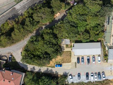 Aerial view of a parking lot with several cars parked near a building surrounded by dense green trees and vegetation in Istanbul Istanbul Turkiye. Aerial view of a parking lot with several cars parked near a building surrounded by dense green trees and vegetation in Istanbul Istanbul Turkiye.