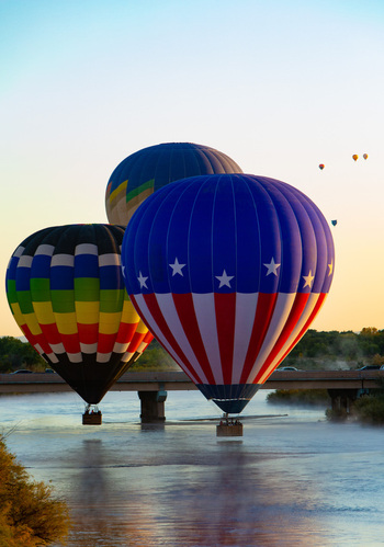 Albuquerque United States 11 October 2017 View of colorful hot air balloons floating over the Rio Grande river under a soft pastel sky creating a vibrant spectacle. Albuquerque United States 11 October 2017 View of colorful hot air balloons floating over the Rio Grande river under a soft pastel sky creating a vibrant spectacle.
