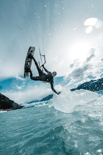 View of a kitesurfer performing a jump over the icy water near the Perito Moreno glacier in Perito Moreno Santa Cruz Province Argentina. View of a kitesurfer performing a jump over the icy water near the Perito Moreno glacier in Perito Moreno Santa Cruz Province Argentina.