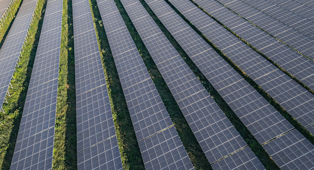 Aerial view of solar photovoltaic panels arranged in geometric rows at a utility scale solar farm in Le Pouzin Auvergne Rhone Alpes France. Aerial view of solar photovoltaic panels arranged in geometric rows at a utility scale solar farm in Le Pouzin Auvergne Rhone Alpes France.