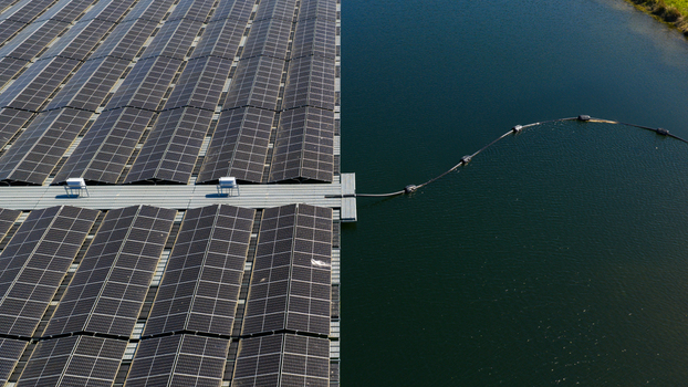 Aerial view of a large floating solar farm with rows of photovoltaic panels on a calm body of water in Zwolle Overijssel Netherlands. Aerial view of a large floating solar farm with rows of photovoltaic panels on a calm body of water in Zwolle Overijssel Netherlands.