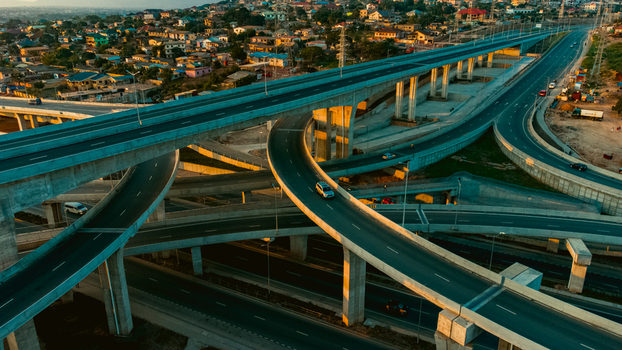 Aerial view of the multi level Pokuase interchange with concrete overpasses traffic and urban sprawl during the golden hour in Ga North Municipal Greater Accra Region Ghana. Aerial view of the multi level Pokuase interchange with concrete overpasses traffic and urban sprawl during the golden hour in Ga North Municipal Greater Accra Region Ghana.