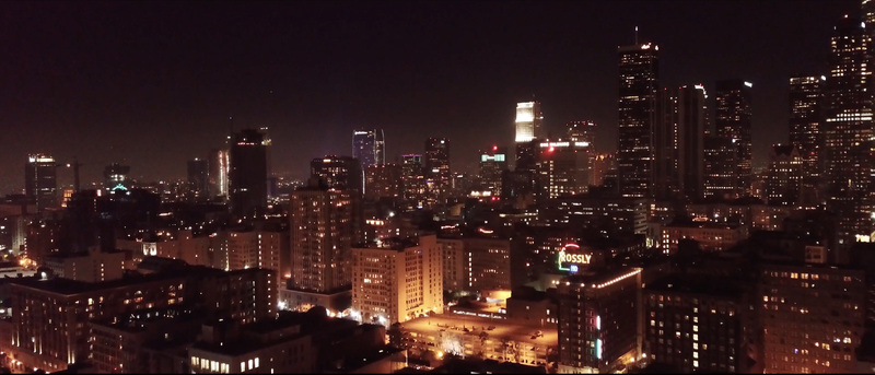 Aerial view of the illuminated Los Angeles skyline at night featuring glowing skyscrapers and dense urban architecture in Los Angeles California United States.