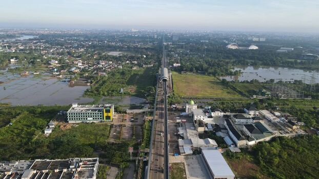 Aerial view of the Jakabaring area with the light rail transit line crossing green landscapes buildings and water bodies in Kecamatan Seberang Ulu I Sumatera Selatan Indonesia. Aerial view of the Jakabaring area with the light rail transit line crossing green landscapes buildings and water bodies in Kecamatan Seberang Ulu I Sumatera Selatan Indonesia.