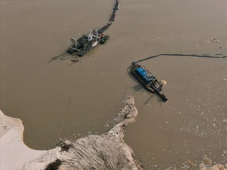 Aerial view of two industrial dredgers operating in a calm lake with sandy shorelines and clear water in Dulmen North Rhine Westphalia Germany. Aerial view of two industrial dredgers operating in a calm lake with sandy shorelines and clear water in Dulmen North Rhine Westphalia Germany.