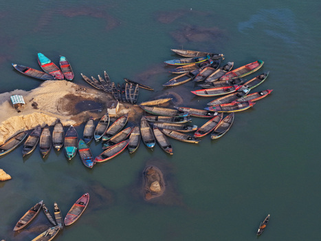 Aerial view of Jadukata River with numerous wooden boats moored along the sandy riverbank in Sunamganj Sylhet Division Bangladesh. Aerial view of Jadukata River with numerous wooden boats moored along the sandy riverbank in Sunamganj Sylhet Division Bangladesh.