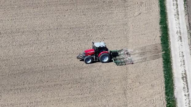 Aerial view of tractor tilling field France.