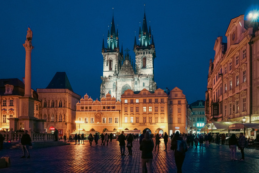 Prague Czechia 03 November 2021 View of Church of Our Lady before Tyn illuminated at night with people walking in the Old Town Square. Prague Czechia 03 November 2021 View of Church of Our Lady before Tyn illuminated at night with people walking in the Old Town Square.
