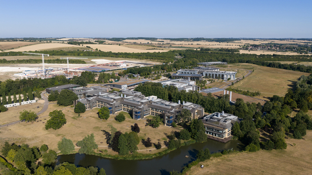 Aerial view of the Wellcome Genome Campus featuring modern research buildings surrounding parkland and a small lake in Hinxton England United Kingdom. Aerial view of the Wellcome Genome Campus featuring modern research buildings surrounding parkland and a small lake in Hinxton England United Kingdom.