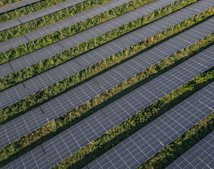 Aerial view of solar photovoltaic panels arranged in geometric rows at a utility scale solar farm in Le Pouzin Auvergne Rhone Alpes France. Aerial view of solar photovoltaic panels arranged in geometric rows at a utility scale solar farm in Le Pouzin Auvergne Rhone Alpes France.