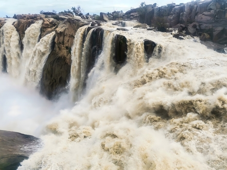View of the powerful Augrabies Falls with immense torrents of water plunging into the rocky gorge surrounded by dramatic cliffs and rising mist in Augrabies Northern Cape South Africa.