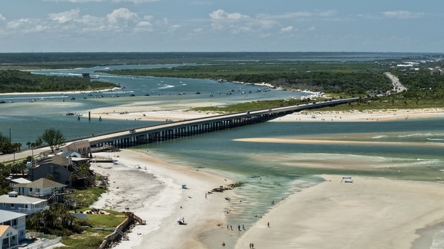 Aerial view of Matanzas Inlet showing the bridge crossing the water sandy beaches coastal vegetation and boats in the inlet in St. Johns County Florida United States. Aerial view of Matanzas Inlet showing the bridge crossing the water sandy beaches coastal vegetation and boats in the inlet in St. Johns County Florida United States.