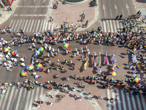 Guadalajara Mexico 01 June 2019 Aerial view of the LGBT pride parade with people walking along the street carrying rainbow flags and umbrellas.