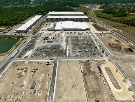 Aerial view of the Foundry Lane industrial construction site featuring large warehouses and expansive parking lots under development in World Golf Village Florida United States.