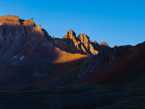 Aerial view of Mount Sneffels in the San Juan Mountain Range illuminated by golden hour light with rugged rocky peaks and shadows in Yankee Boy Basin Ouray Colorado United States. Aerial view of Mount Sneffels in the San Juan Mountain Range illuminated by golden hour light with rugged rocky peaks and shadows in Yankee Boy Basin Ouray Colorado United States.