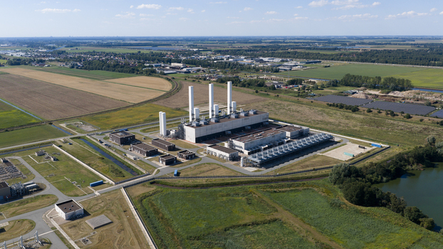 Aerial view of the Gasunie Air Products nitrogen factory featuring tall white chimneys industrial infrastructure and surrounding green fields in Muntendam Groningen Netherlands.