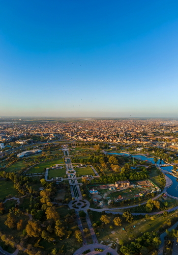 Aerial view of Minar e Pakistan surrounded by lush green gardens water features and the sprawling urban landscape of Lahore Punjab Pakistan.