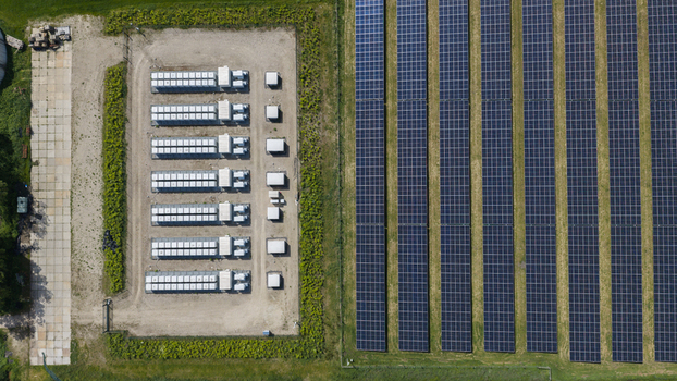 Aerial view of a solar farm with rows of photovoltaic panels and a battery energy storage system facility in Wanneperveen Overijssel Netherlands. Aerial view of a solar farm with rows of photovoltaic panels and a battery energy storage system facility in Wanneperveen Overijssel Netherlands.