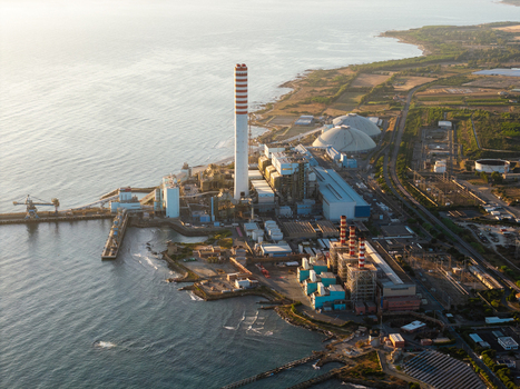 Aerial view of the Centrale Termoelettrica Torrevaldaliga Nord power plant with its tall chimney and industrial structures along the coastline at sunset in Civitavecchia Lazio Italy. Aerial view of the Centrale Termoelettrica Torrevaldaliga Nord power plant with its tall chimney and industrial structures along the coastline at sunset in Civitavecchia Lazio Italy.