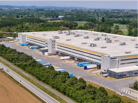 Torrazza Piemonte Italy 02 May 2026 Aerial view of Amazon TRN1 fulfillment center with blue delivery trucks at loading bays and lush green landscape in the background. Torrazza Piemonte Italy 02 May 2026 Aerial view of Amazon TRN1 fulfillment center with blue delivery trucks at loading bays and lush green landscape in the background.