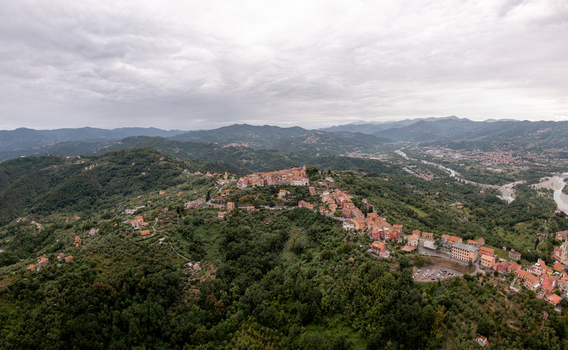 Aerial view of Vezzano Ligure a historic hilltop village surrounded by lush green hills olive groves and a winding river in Vezzano Ligure Liguria Italy.