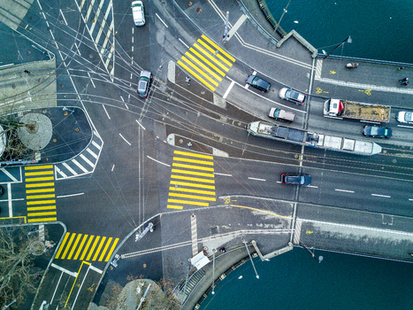 Aerial view of a busy urban intersection in Zurich with a tram crossing the bridge yellow pedestrian crossings and cars moving through the city center Zurich Zurich Switzerland. Aerial view of a busy urban intersection in Zurich with a tram crossing the bridge yellow pedestrian crossings and cars moving through the city center Zurich Zurich Switzerland.