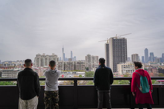 Guangzhou Guangdong Province China 23 February 2024 View of people looking at the Guangzhou skyline with the Canton Tower modern skyscrapers and construction cranes under a cloudy sky. Guangzhou Guangdong Province China 23 February 2024 View of people looking at the Guangzhou skyline with the Canton Tower modern skyscrapers and construction cranes under a cloudy sky.