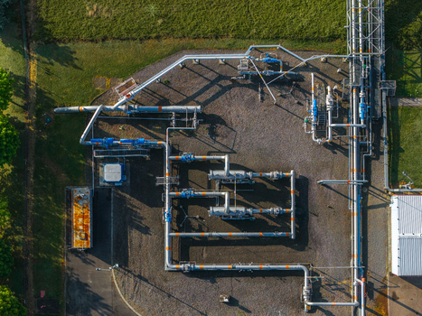 Aerial view of the UGS Damborice facility featuring complex industrial pipelines valves and infrastructure on gravel ground surrounded by green grass in Damborice South Moravian Region Czechia. Aerial view of the UGS Damborice facility featuring complex industrial pipelines valves and infrastructure on gravel ground surrounded by green grass in Damborice South Moravian Region Czechia.