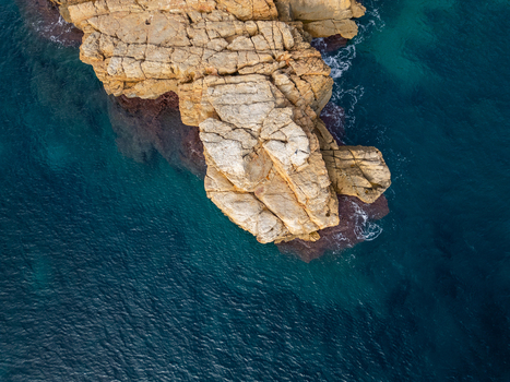 Aerial view of the rocky coastline of Cala Llebeig with turquoise waters and rugged cliffs in El Poble Nou de Benitatxell Valencian Community Spain.