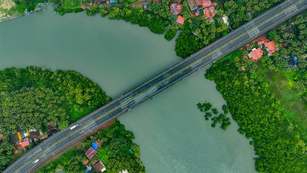 Aerial view of the Galgibaga Bridge spanning the river surrounded by lush green mangroves and tropical vegetation in Canacona Goa India.