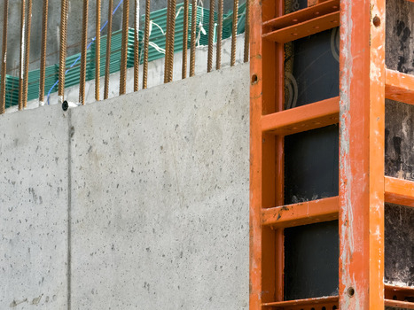 View of a concrete wall with orange metal formwork and steel rebar at a construction site in Sariyer Istanbul Turkiye. View of a concrete wall with orange metal formwork and steel rebar at a construction site in Sariyer Istanbul Turkiye.