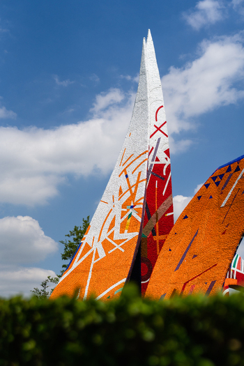 Bratislava Slovakia 09 May 2026 View of a colorful modern sculpture with sharp peaks and mosaic patterns under a blue sky with fluffy clouds.