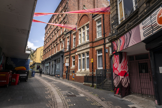 Newcastle upon Tyne United Kingdom 13 July 2026 View of a historic street featuring red brick architecture a former post office building and vibrant overhead streamers. Newcastle upon Tyne United Kingdom 13 July 2026 View of a historic street featuring red brick architecture a former post office building and vibrant overhead streamers.