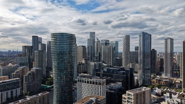 London United Kingdom 16 June 2026 Aerial view of the Canary Wharf financial district skyline featuring modern skyscrapers under a cloudy sky.