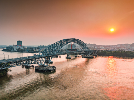 Aerial view of Jembatan Mahakam I spanning the Mahakam River at sunset with golden light reflecting on the water in Kecamatan Samarinda Seberang Kalimantan Timur Indonesia. Aerial view of Jembatan Mahakam I spanning the Mahakam River at sunset with golden light reflecting on the water in Kecamatan Samarinda Seberang Kalimantan Timur Indonesia.