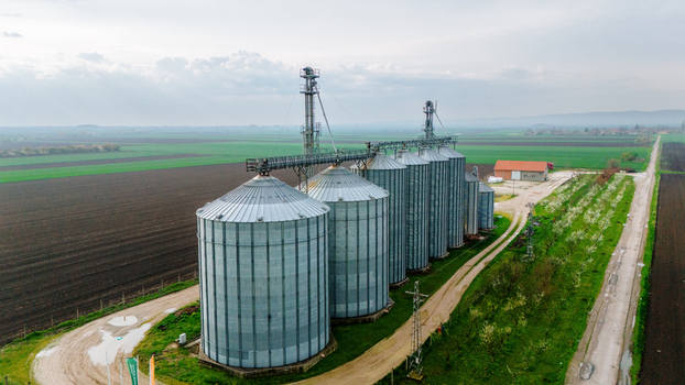 Aerial view of the silver silos standing tall against the backdrop of dark tilled soil and vibrant green fields Sremska Mitrovica Vojvodina Serbia. Aerial view of the silver silos standing tall against the backdrop of dark tilled soil and vibrant green fields Sremska Mitrovica Vojvodina Serbia.