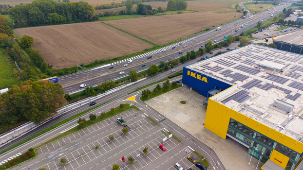 San Giuliano Milanese Lombardia Italy 19 September 2026 Aerial view of IKEA Milano San Giuliano store with blue and yellow facade rooftop solar panels parking lot and highway.