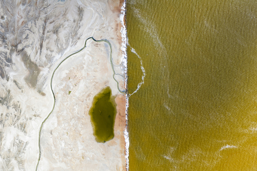 Aerial view of the stark contrast between the golden waters and the pale textured earth divided by a thin strip of shore San Pedro del Pinatar Region of Murcia Spain. Aerial view of the stark contrast between the golden waters and the pale textured earth divided by a thin strip of shore San Pedro del Pinatar Region of Murcia Spain.