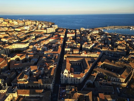 Aerial view of the historic center of Catania featuring the Benedictine Monastery of San Nicolo l Arena and the Mediterranean Sea at sunset Catania Sicily Italy. Aerial view of the historic center of Catania featuring the Benedictine Monastery of San Nicolo l Arena and the Mediterranean Sea at sunset Catania Sicily Italy.