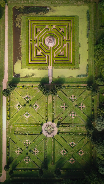 Aerial view of the geometric hedge maze and symmetrical parterre gardens at Chateau de Cormatin in Cormatin Bourgogne Franche Comte France. Aerial view of the geometric hedge maze and symmetrical parterre gardens at Chateau de Cormatin in Cormatin Bourgogne Franche Comte France.