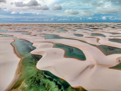 Aerial view of Lagoa Bonita featuring white sand dunes and turquoise lagoons under a cloudy sky in Barreirinhas Maranhao Brazil. Aerial view of Lagoa Bonita featuring white sand dunes and turquoise lagoons under a cloudy sky in Barreirinhas Maranhao Brazil.