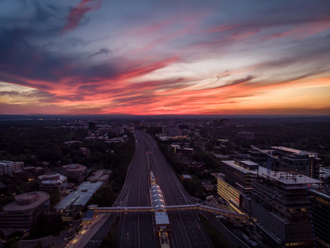 Reston Virginia United States 27 May 2020 Aerial view of the Dulles Toll Road at sunset featuring a pedestrian bridge modern office buildings and a vibrant sky. Reston Virginia United States 27 May 2020 Aerial view of the Dulles Toll Road at sunset featuring a pedestrian bridge modern office buildings and a vibrant sky.