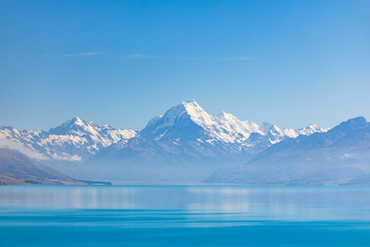 View of snow capped mountains mirrored on the tranquil turquoise lake under a clear blue sky a serene landscape evoking peace and adventure Lake Pukaki Mount Cook Lookout New Zealand. View of snow capped mountains mirrored on the tranquil turquoise lake under a clear blue sky a serene landscape evoking peace and adventure Lake Pukaki Mount Cook Lookout New Zealand.