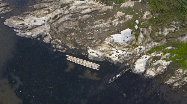 Danau Kerinci Jambi Indonesia 25 September 2026 Aerial view of Danau Kerinci showing a rocky shoreline with a wooden boat and a bamboo raft floating in the dark water. Danau Kerinci Jambi Indonesia 25 September 2026 Aerial view of Danau Kerinci showing a rocky shoreline with a wooden boat and a bamboo raft floating in the dark water.