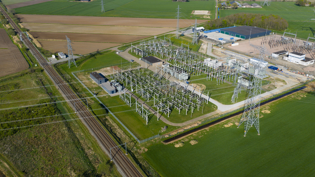 Aerial view of an electrical substation with high voltage power lines pylons and transformers situated next to a railway track and green fields in Zwolle Overijssel Netherlands. Aerial view of an electrical substation with high voltage power lines pylons and transformers situated next to a railway track and green fields in Zwolle Overijssel Netherlands.