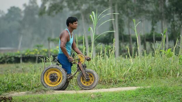 View of a man with a disability riding a custom tricycle Bangladesh.