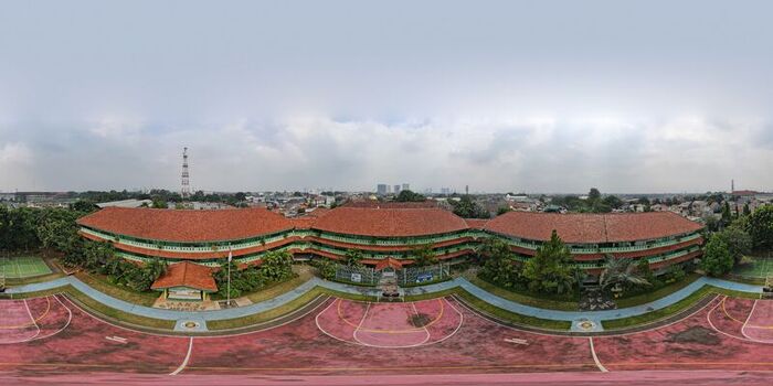 Aerial view of the school building at Pondok Labu featuring red tiled roofs green walls and a surrounding sports court under a cloudy sky in Cilandak Jakarta Indonesia. Aerial view of the school building at Pondok Labu featuring red tiled roofs green walls and a surrounding sports court under a cloudy sky in Cilandak Jakarta Indonesia.