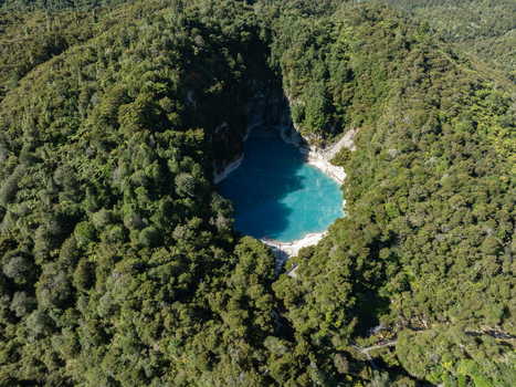 Aerial view of Emerald pool nestled amid dense green forest creating a striking contrast of turquoise and verdant hues Waimangu Bay of Plenty Region New Zealand. Aerial view of Emerald pool nestled amid dense green forest creating a striking contrast of turquoise and verdant hues Waimangu Bay of Plenty Region New Zealand.