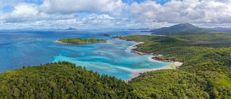 Aerial view of Chance Bay with turquoise waters sandy coastline and lush tropical forest on the Whitsunday Islands in Whitsundays Queensland Australia. Aerial view of Chance Bay with turquoise waters sandy coastline and lush tropical forest on the Whitsunday Islands in Whitsundays Queensland Australia.
