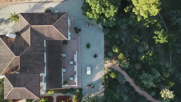 Aerial view of a villa with tiled roofs and a lush garden Spain.